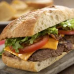 Classic steak sandwich with melted cheese, caramelized onions, and arugula on a ciabatta roll